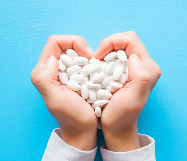 hand with medicines forming a heart