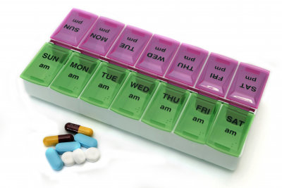 Daily medicine drug organizing box system with morning and afternoon compartments and medication.