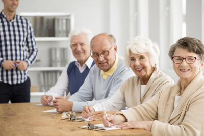 group of happy seniors and their tutor